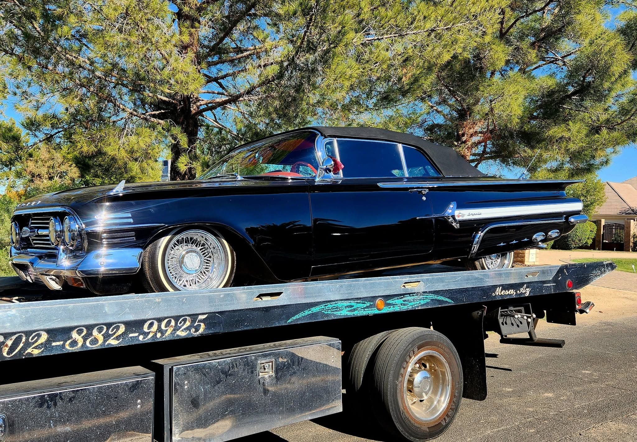 F&S Towing flatbed hauling a black 1960 Chevrolet Impala convertible